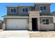 Two-story home boasts a neutral color palette with stone veneer accents and a two-car garage, offering modern curb appeal at 7385 W Buckhorn Trl, Peoria, AZ 85383
