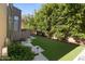 Manicured backyard with artificial turf, stone pavers, and mature trees for added privacy at 742 W Puget Ave, Phoenix, AZ 85021