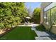 Lush backyard with green artificial turf, stone walkways, and shaded seating area at 742 W Puget Ave, Phoenix, AZ 85021