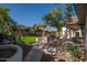 The backyard features green turf, an outdoor kitchen and a view of the pool at 7590 W Firebird Dr, Glendale, AZ 85308