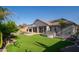 A backyard with artificial grass, a outdoor kitchen and desert landscaping at 7590 W Firebird Dr, Glendale, AZ 85308