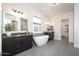 Elegant bathroom featuring dual vanities, a soaking tub, modern light fixtures, and neutral tile flooring at 7590 W Firebird Dr, Glendale, AZ 85308
