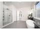 Bright bathroom showcasing a modern shower, soaking tub, and sleek vanity with stone countertops at 7590 W Firebird Dr, Glendale, AZ 85308
