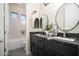 Bathroom with a dual sink vanity, modern lighting, and separate toilet at 7590 W Firebird Dr, Glendale, AZ 85308