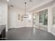 Bright dining room with gray tile flooring, modern lighting, and views of the backyard through sliding glass doors at 7590 W Firebird Dr, Glendale, AZ 85308
