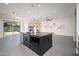 Kitchen island with dark marble countertop, modern faucet, and stainless steel dishwasher in a brightly lit open space at 7590 W Firebird Dr, Glendale, AZ 85308