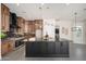 Modern kitchen with dark wood cabinets, a black marble island, and stainless steel appliances at 7590 W Firebird Dr, Glendale, AZ 85308