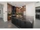 Elegant kitchen with dark wood cabinets, a black marble island, and stainless steel appliances at 7590 W Firebird Dr, Glendale, AZ 85308