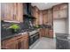 Modern kitchen boasts stainless steel appliances, custom wood cabinets, and stunning dark marble countertops and backsplash at 7590 W Firebird Dr, Glendale, AZ 85308