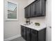 This laundry room features storage cabinets, countertops, and a window at 7590 W Firebird Dr, Glendale, AZ 85308