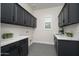 This laundry room includes upper and lower cabinets with stone countertops at 7590 W Firebird Dr, Glendale, AZ 85308