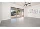 Bright living room featuring modern ceiling fan, neutral walls, and sliding glass doors leading to the outdoor patio at 7590 W Firebird Dr, Glendale, AZ 85308
