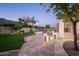 A well-appointed outdoor kitchen with a built-in grill complements the lush backyard and travertine patio at 7590 W Firebird Dr, Glendale, AZ 85308