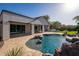 Backyard pool with stone features and a spacious patio, perfect for outdoor entertaining at 7590 W Firebird Dr, Glendale, AZ 85308