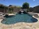 Backyard pool features a rock waterfall and beautiful stone pavers at 7590 W Firebird Dr, Glendale, AZ 85308