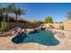 Beautiful pool with rock features and desert landscaping at 7590 W Firebird Dr, Glendale, AZ 85308