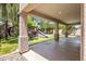 Covered backyard patio overlooking green lawn and play structure at 7758 E Nestling Way, Scottsdale, AZ 85255