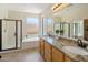 Bright bathroom with granite countertop, dual sinks, tub, and walk-in shower at 7758 E Nestling Way, Scottsdale, AZ 85255