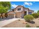 Charming two-story home featuring a well-manicured front yard, desert landscaping, and a three-car garage at 7758 E Nestling Way, Scottsdale, AZ 85255