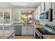 Bright kitchen with granite countertops, modern appliances, and a view of the backyard through a large window at 7758 E Nestling Way, Scottsdale, AZ 85255