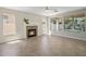 Bright living room featuring a stone fireplace, large windows, and neutral-toned tile flooring at 7758 E Nestling Way, Scottsdale, AZ 85255