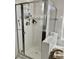 This bathroom features a glass-enclosed shower and bathtub with light-toned walls and diamond accents at 7925 S 52Nd Dr, Laveen, AZ 85339