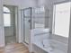 Bright bathroom featuring a soaking tub and shower with glass door and tile accents at 7925 S 52Nd Dr, Laveen, AZ 85339