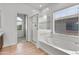 Bathroom featuring a glass-enclosed shower and soaking tub under a bright window with white tile surround at 7925 S 52Nd Dr, Laveen, AZ 85339