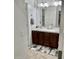 This bathroom has a beautiful vanity with double sinks, warm-toned cabinets and a stylish carpet at 7925 S 52Nd Dr, Laveen, AZ 85339