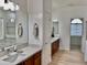 Well-lit bathroom featuring dual sinks with wood cabinets and a view of the tub and shower at 7925 S 52Nd Dr, Laveen, AZ 85339
