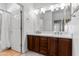 Bathroom with double vanity, wood cabinets, white quartz countertops and decorative mirror at 7925 S 52Nd Dr, Laveen, AZ 85339