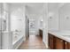 Bathroom featuring double vanity, wood cabinets, white quartz countertops, wood-look floors and soaking tub at 7925 S 52Nd Dr, Laveen, AZ 85339
