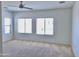 Bright, airy bedroom featuring neutral carpet, ceiling fan, and ample natural light at 7925 S 52Nd Dr, Laveen, AZ 85339