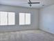 Spacious bedroom featuring neutral carpet, large windows, and modern ceiling fan at 7925 S 52Nd Dr, Laveen, AZ 85339
