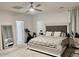 This bedroom has a ceiling fan and boasts neutral tones and has a tufted headboard with a stylish carpet at 7925 S 52Nd Dr, Laveen, AZ 85339