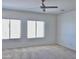 Spacious bedroom featuring neutral carpet, large windows, and modern ceiling fan at 7925 S 52Nd Dr, Laveen, AZ 85339