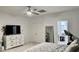 This bedroom has neutral walls and carpet with white trim, a ceiling fan and a TV at 7925 S 52Nd Dr, Laveen, AZ 85339