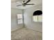 Neutral carpeted bedroom with ceiling fan and a partial view of a window at 7925 S 52Nd Dr, Laveen, AZ 85339