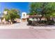 Charming two-story home showcasing its manicured front yard with mature trees enhancing its curb appeal under a bright blue sky at 7925 S 52Nd Dr, Laveen, AZ 85339