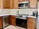 Modern kitchen featuring stainless steel appliances, stylish countertops, and wooden cabinets at 7925 S 52Nd Dr, Laveen, AZ 85339
