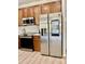 Modern kitchen features stainless steel refrigerator, wooden cabinets, and sleek countertops at 7925 S 52Nd Dr, Laveen, AZ 85339