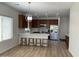 Modern kitchen boasts a central island, stainless steel appliances, and elegant lighting on wood-style flooring at 7925 S 52Nd Dr, Laveen, AZ 85339