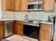 Modern kitchen featuring stainless steel appliances, stylish countertops, and wooden cabinets at 7925 S 52Nd Dr, Laveen, AZ 85339