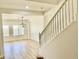 Bright living room featuring wood-look floors, staircase, and modern light fixture at 7925 S 52Nd Dr, Laveen, AZ 85339