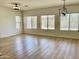 Spacious living room with multiple windows and wood-look floors at 7925 S 52Nd Dr, Laveen, AZ 85339