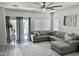 Comfortable living room showcasing a large sectional sofa, neutral decor, and sliding glass door to backyard at 7925 S 52Nd Dr, Laveen, AZ 85339