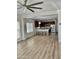 Spacious living area merges with modern kitchen, featuring barstool seating, and wood-style flooring at 7925 S 52Nd Dr, Laveen, AZ 85339