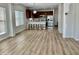 Open-concept living room with modern kitchen, sleek countertops, and barstool seating on wood-style flooring at 7925 S 52Nd Dr, Laveen, AZ 85339