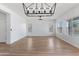 Open-concept living room with hardwood floors, abundant natural light, and modern chandelier, perfect for entertaining and relaxation at 7925 S 52Nd Dr, Laveen, AZ 85339