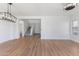 Spacious living area with hardwood flooring, featuring an elegant chandelier and seamless flow to the entry and staircase at 7925 S 52Nd Dr, Laveen, AZ 85339